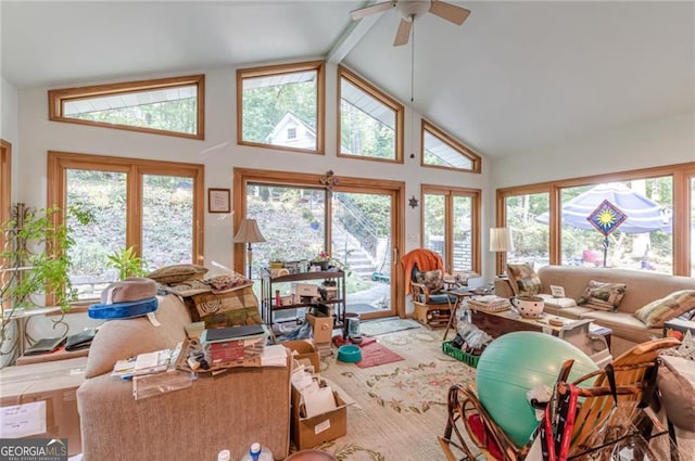 living room featuring ceiling fan, high vaulted ceiling, beamed ceiling, and plenty of natural light