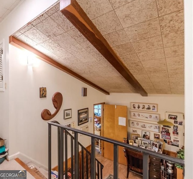 hall featuring wood-type flooring and vaulted ceiling with beams