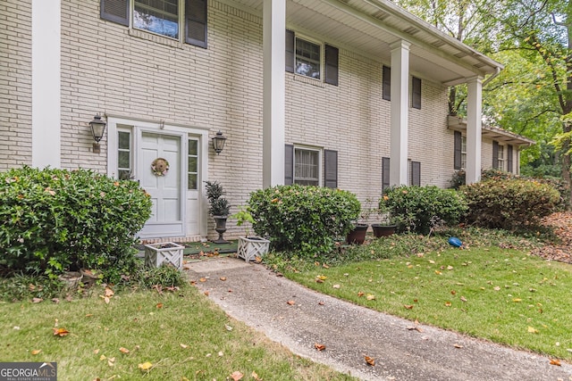 view of exterior entry with a yard