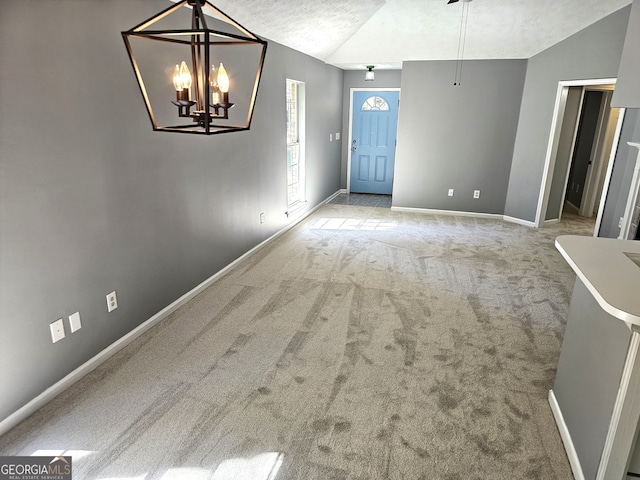 interior space featuring a textured ceiling, a chandelier, and vaulted ceiling