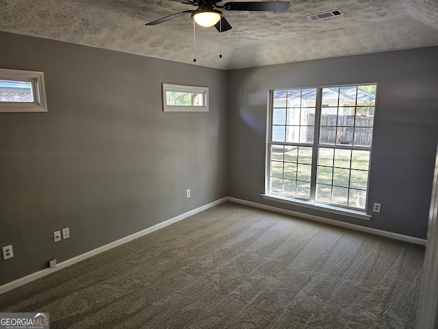 empty room with a textured ceiling, carpet flooring, and ceiling fan