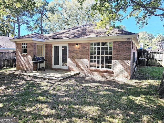 back of house featuring a yard and french doors