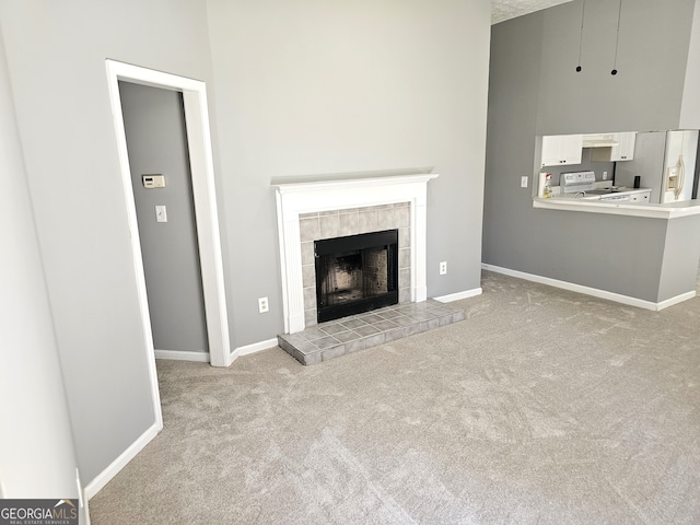 unfurnished living room featuring light carpet and a tile fireplace