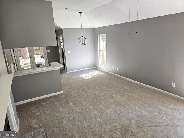 unfurnished living room with dark colored carpet, a textured ceiling, and vaulted ceiling