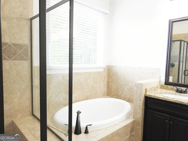 bathroom with vanity, plus walk in shower, and a healthy amount of sunlight