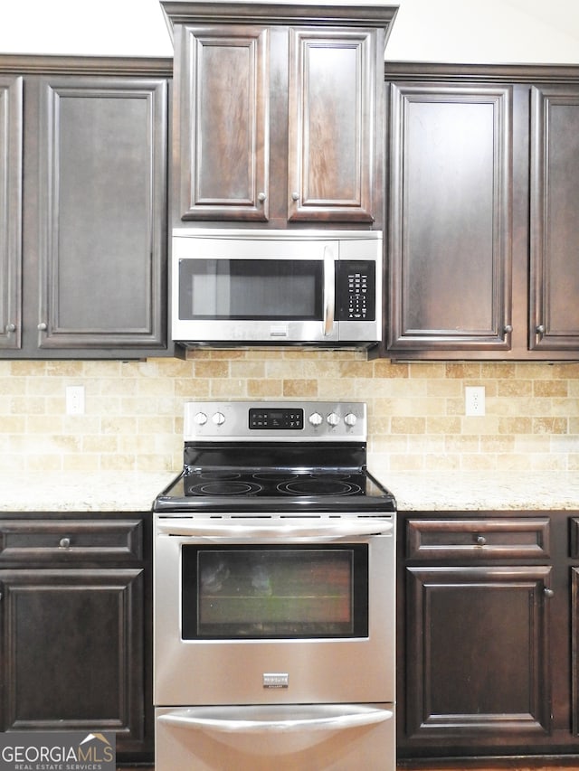 kitchen featuring appliances with stainless steel finishes, decorative backsplash, dark brown cabinets, and light stone counters