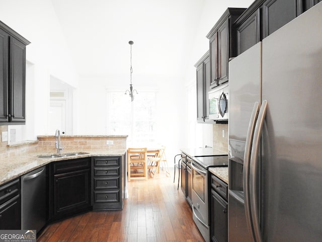 kitchen with stainless steel appliances, sink, dark hardwood / wood-style flooring, and tasteful backsplash