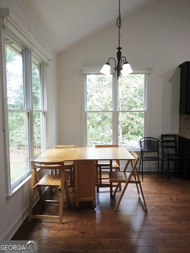 dining room with a notable chandelier, lofted ceiling, dark wood-type flooring, and a healthy amount of sunlight