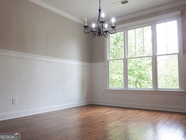 empty room with ornamental molding, plenty of natural light, and dark wood-type flooring