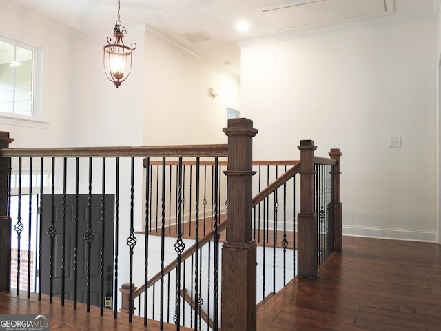 stairway with ornamental molding and hardwood / wood-style flooring