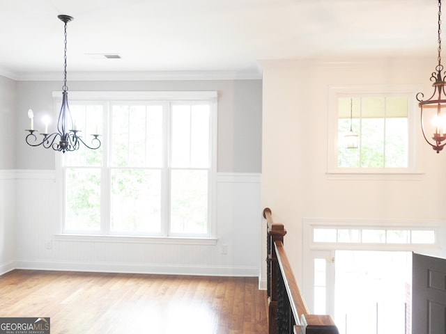 foyer featuring ornamental molding, hardwood / wood-style flooring, and an inviting chandelier