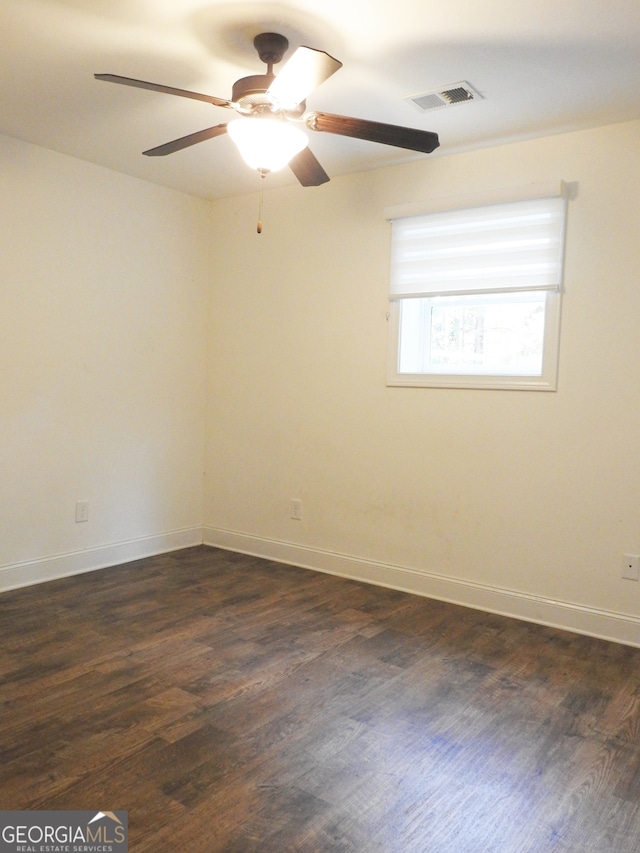 spare room featuring dark hardwood / wood-style flooring and ceiling fan