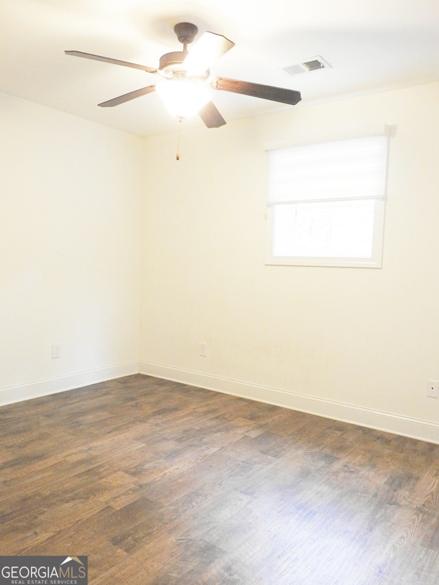 empty room with ceiling fan and dark hardwood / wood-style flooring