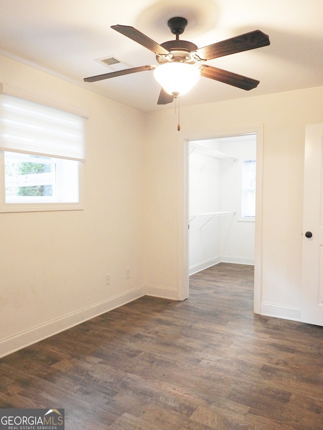 unfurnished room with ceiling fan, dark hardwood / wood-style floors, and a healthy amount of sunlight