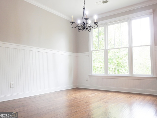 empty room with light hardwood / wood-style floors, a healthy amount of sunlight, and crown molding