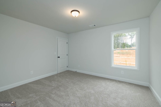 spare room featuring light carpet