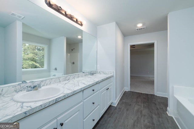 bathroom featuring plus walk in shower, wood-type flooring, and vanity