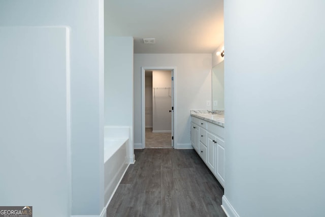 bathroom with a bathing tub, vanity, and hardwood / wood-style floors