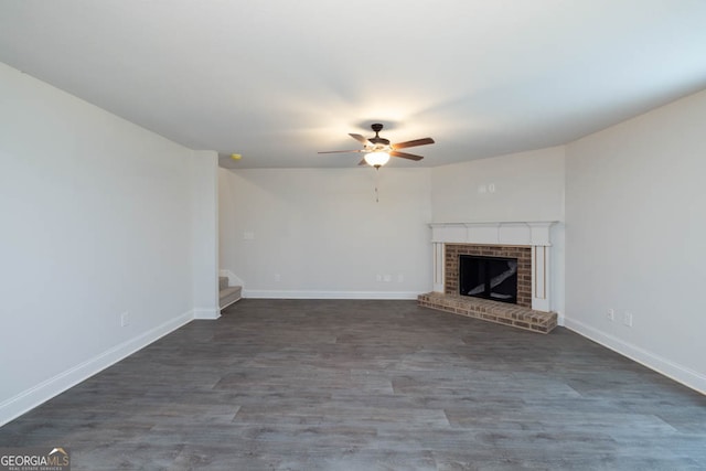 unfurnished living room featuring dark wood-type flooring, ceiling fan, and a fireplace