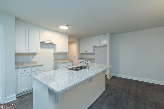 kitchen featuring white cabinets, a kitchen island with sink, and sink