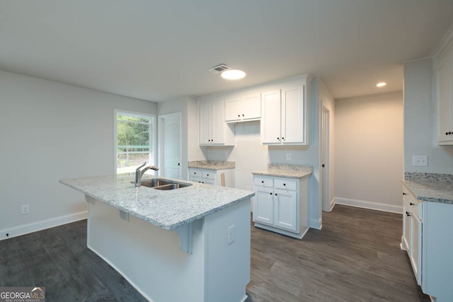 kitchen with white cabinets, a center island with sink, dark hardwood / wood-style floors, and sink