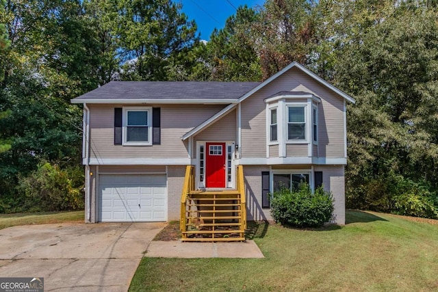 raised ranch featuring a garage and a front lawn