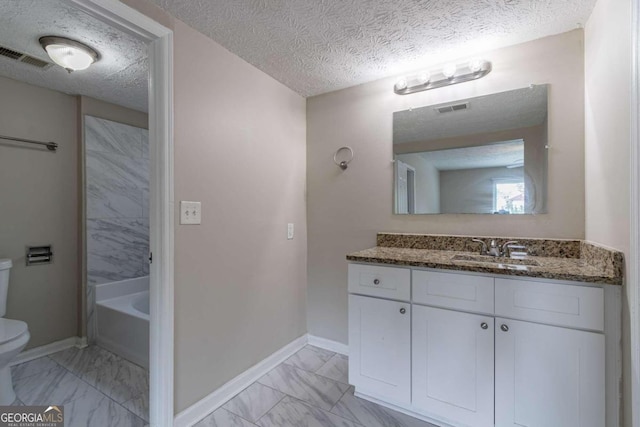 bathroom featuring a textured ceiling, vanity, and toilet