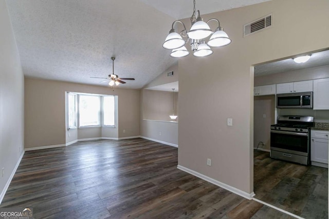 interior space featuring white cabinets, dark wood-type flooring, stainless steel appliances, ceiling fan with notable chandelier, and vaulted ceiling