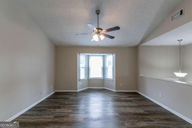 unfurnished room featuring ceiling fan, a textured ceiling, and dark wood-type flooring