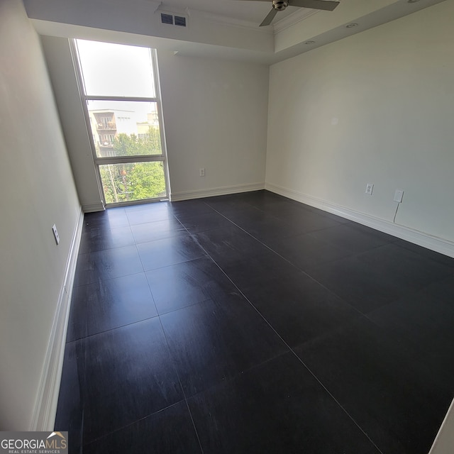 tiled empty room featuring ceiling fan