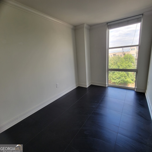 tiled empty room featuring crown molding