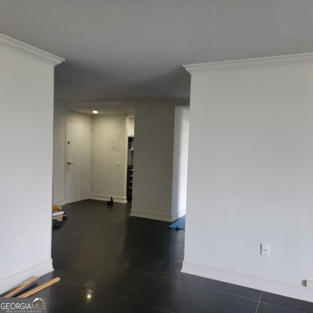 empty room with ornamental molding and dark tile patterned floors