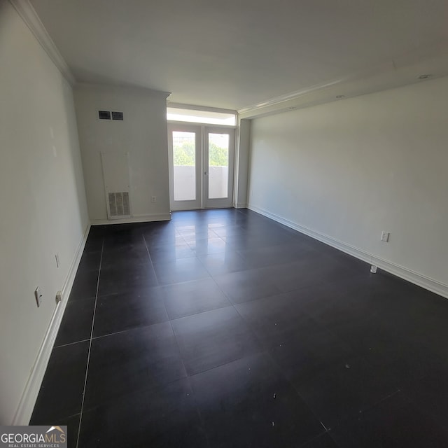 tiled spare room featuring ornamental molding and french doors