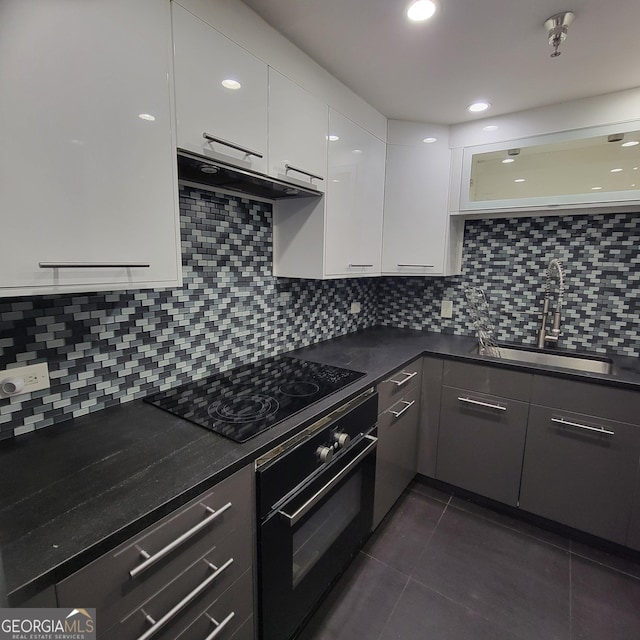 375 Ralph Mcgill Blvd Unit 505, Atlanta, GA 30312 - kitchen with oven, black electric stovetop, under cabinet range hood, white cabinetry, and dark countertops