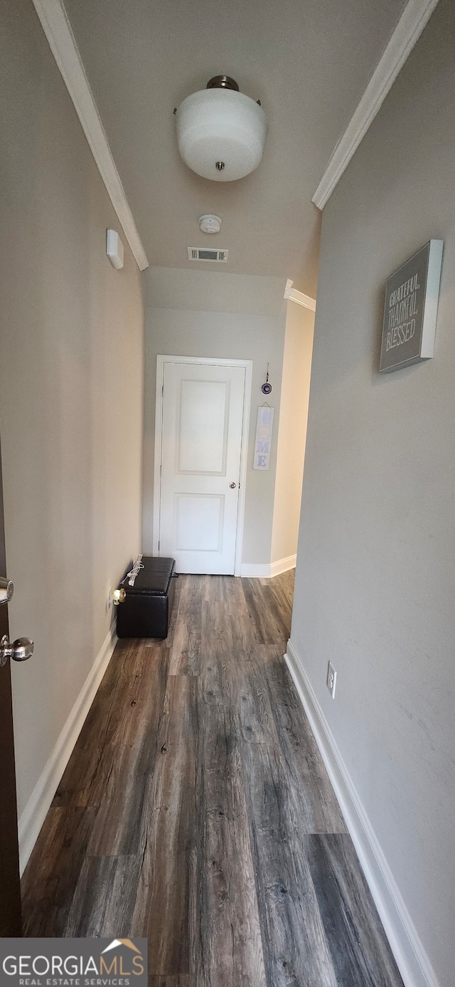 hall featuring ornamental molding and dark hardwood / wood-style floors