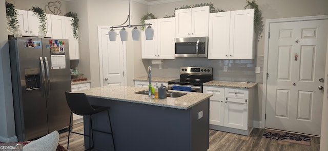 kitchen featuring a center island with sink, white cabinetry, stainless steel appliances, sink, and light stone counters