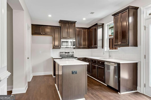 kitchen featuring sink, stainless steel appliances, dark hardwood / wood-style flooring, and a kitchen island