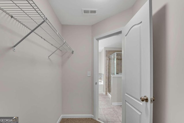 spacious closet featuring light tile patterned floors