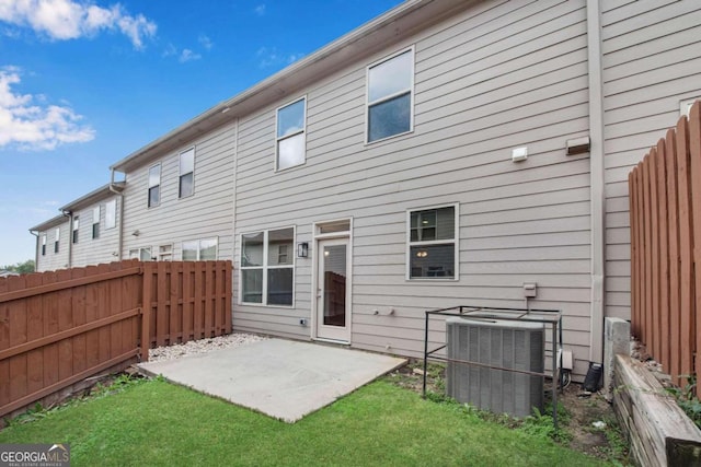 back of house with central AC unit, a yard, and a patio area