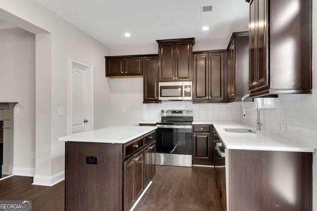 kitchen with a center island, tasteful backsplash, dark wood-type flooring, sink, and stainless steel appliances