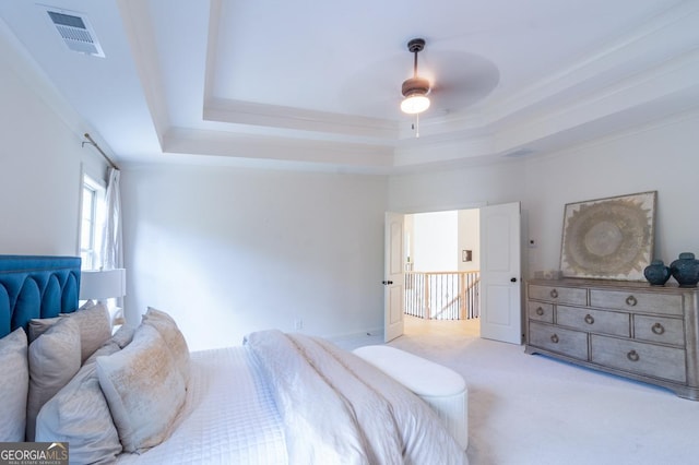 bedroom featuring ceiling fan, light colored carpet, a raised ceiling, and crown molding