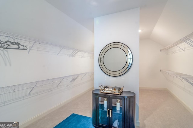 walk in closet featuring vaulted ceiling and carpet flooring