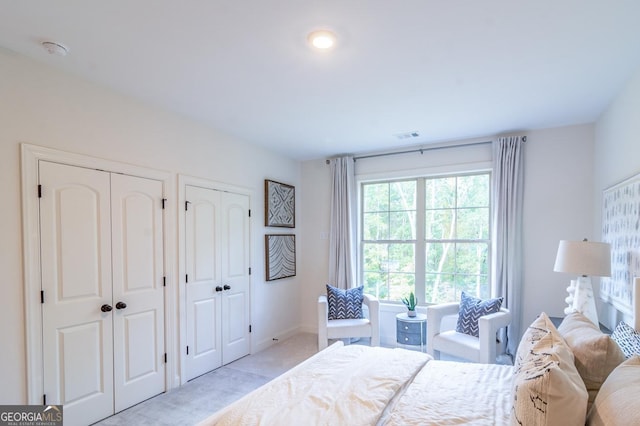 carpeted bedroom featuring multiple closets