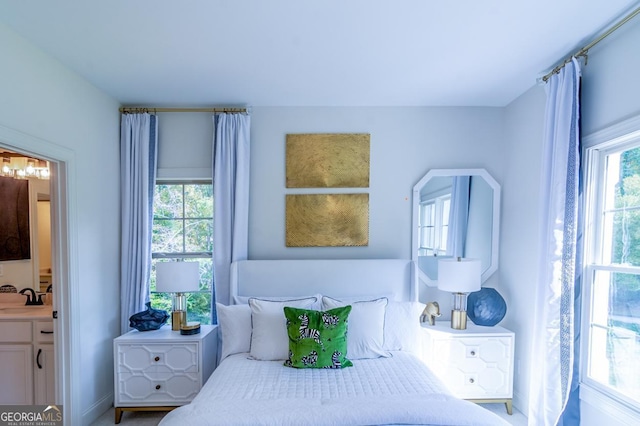 bedroom featuring connected bathroom and sink