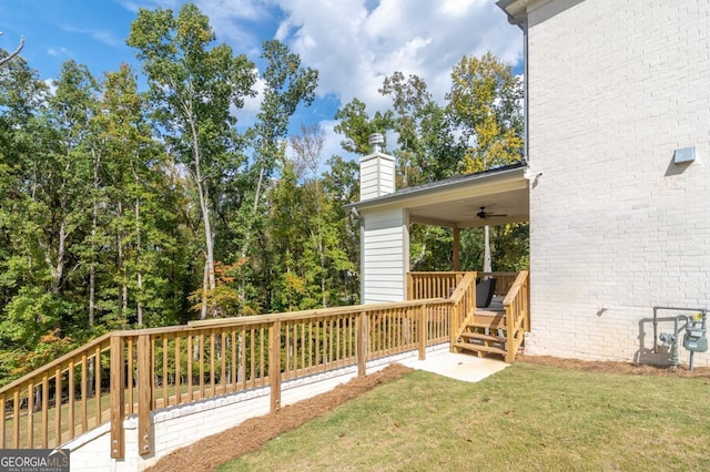 wooden deck featuring ceiling fan and a yard