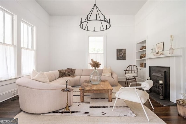 living room featuring a healthy amount of sunlight, dark wood-type flooring, and built in features