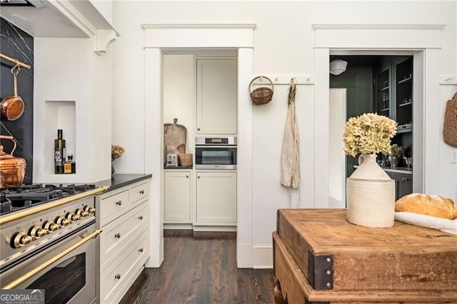 kitchen featuring stainless steel appliances, white cabinetry, and dark wood-type flooring