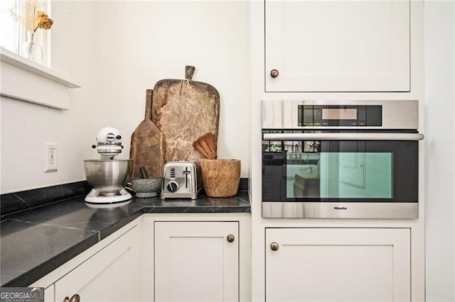 kitchen with white cabinets and oven