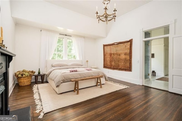 bedroom with an inviting chandelier and dark hardwood / wood-style floors