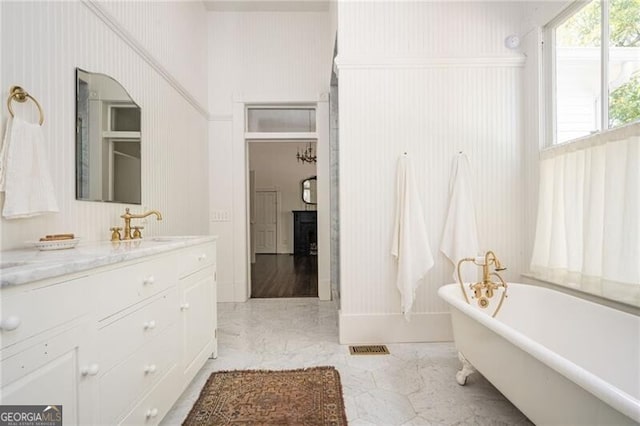 bathroom featuring vanity, a washtub, and a fireplace